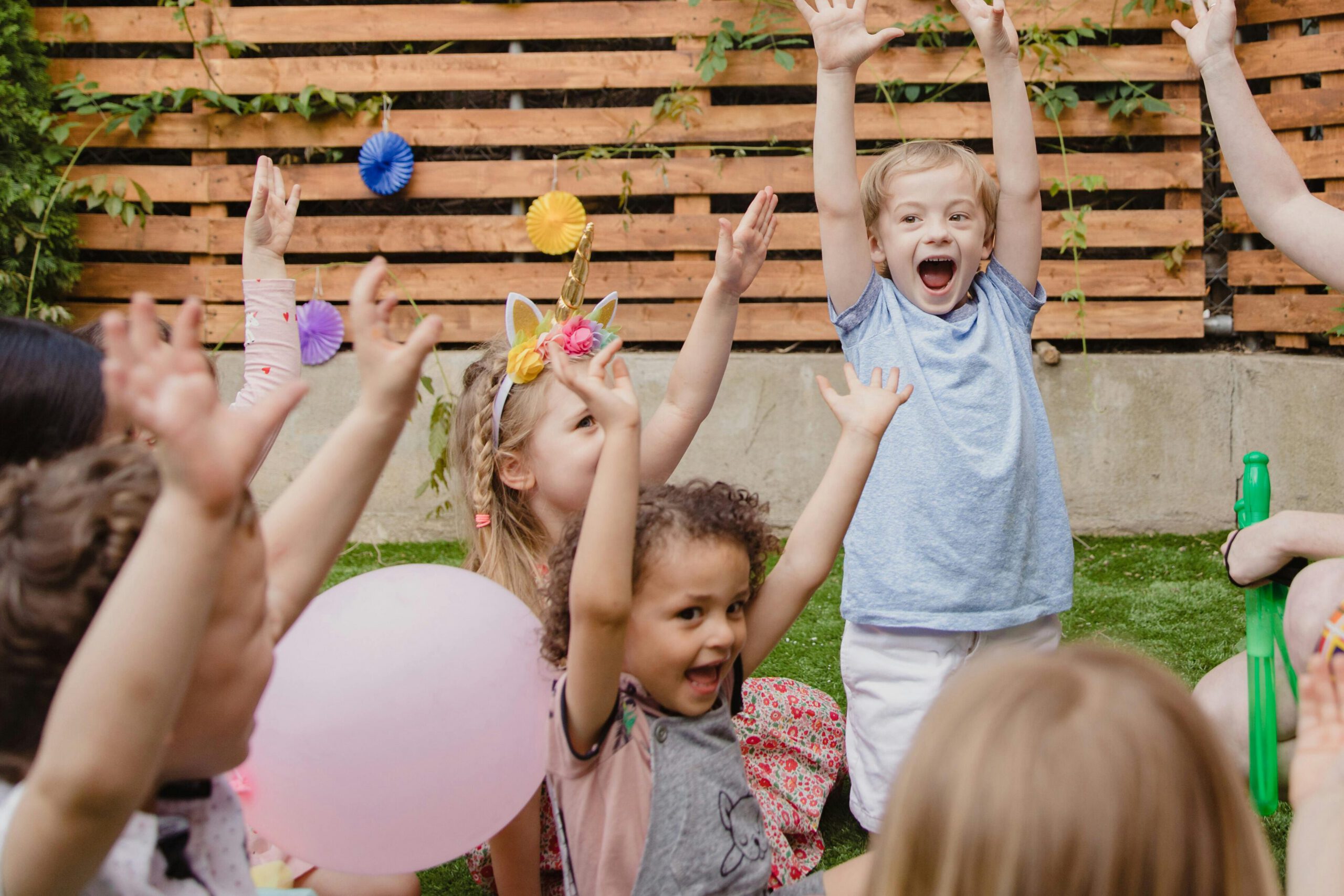 Kids and adults having fun at a lively outdoor birthday party.